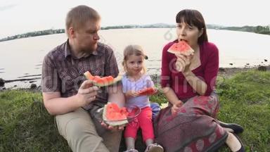 <strong>大家一起</strong>吃西瓜快乐的一家人在夏日的池塘边野餐
